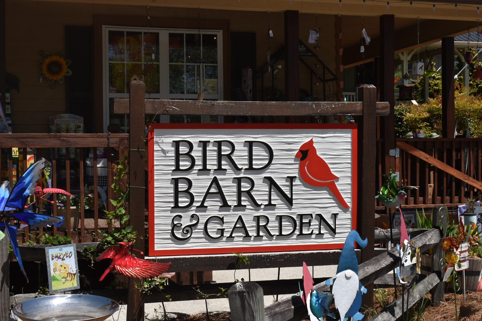 The exterior of a garden supply store with gnomes and bird figurines out front.