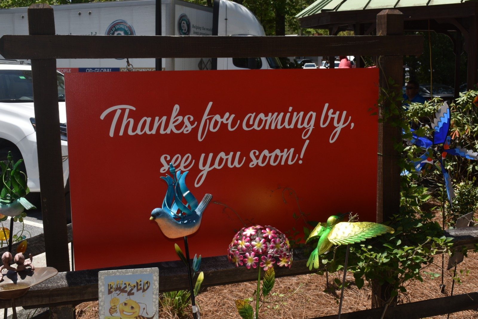 A large display sign at the exit of the garden store which says, "Thanks for coming by, see you soon!"